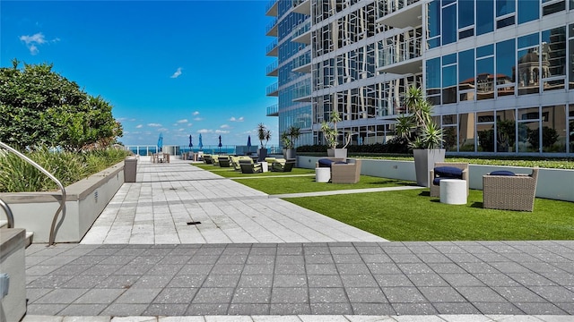 view of community featuring a lawn and a patio