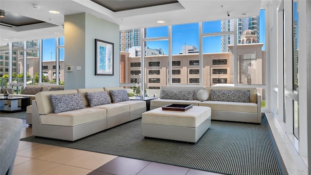 living room featuring a tray ceiling and tile patterned floors