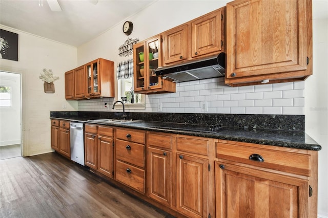 kitchen featuring dishwasher, sink, dark hardwood / wood-style floors, dark stone countertops, and black cooktop