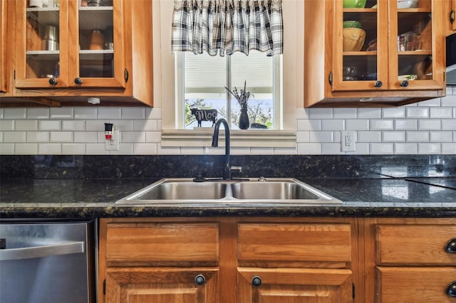 kitchen with decorative backsplash, dark stone counters, dishwasher, and sink