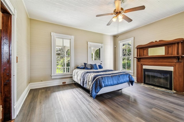 bedroom featuring multiple windows, ceiling fan, and wood-type flooring