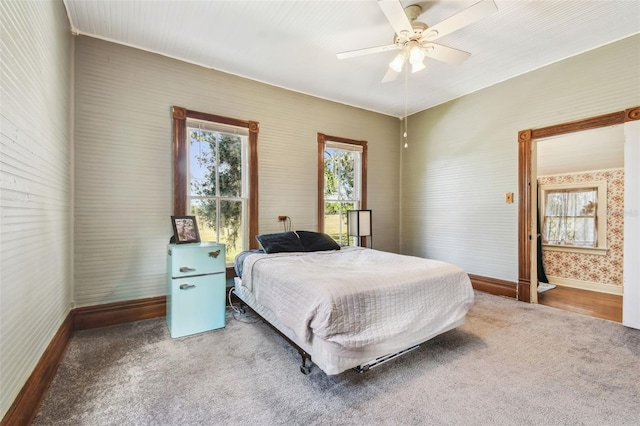 carpeted bedroom with ensuite bath and ceiling fan