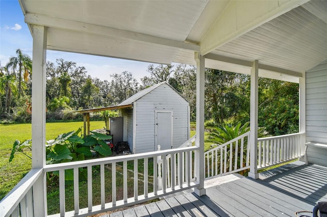 wooden deck featuring a lawn and a storage shed