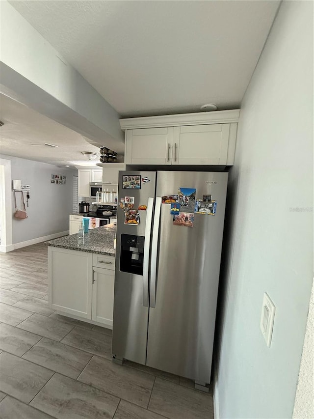 kitchen with stone counters, white cabinetry, and stainless steel appliances