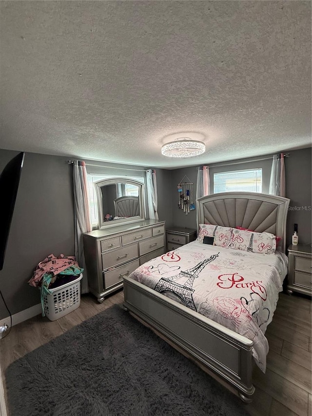 bedroom featuring a textured ceiling and dark hardwood / wood-style floors