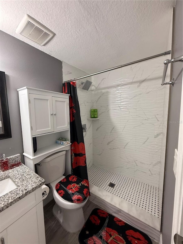 bathroom with vanity, a shower with curtain, toilet, a textured ceiling, and wood-type flooring