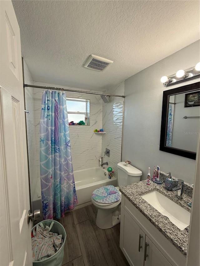 full bathroom featuring vanity, hardwood / wood-style flooring, toilet, shower / bathtub combination with curtain, and a textured ceiling