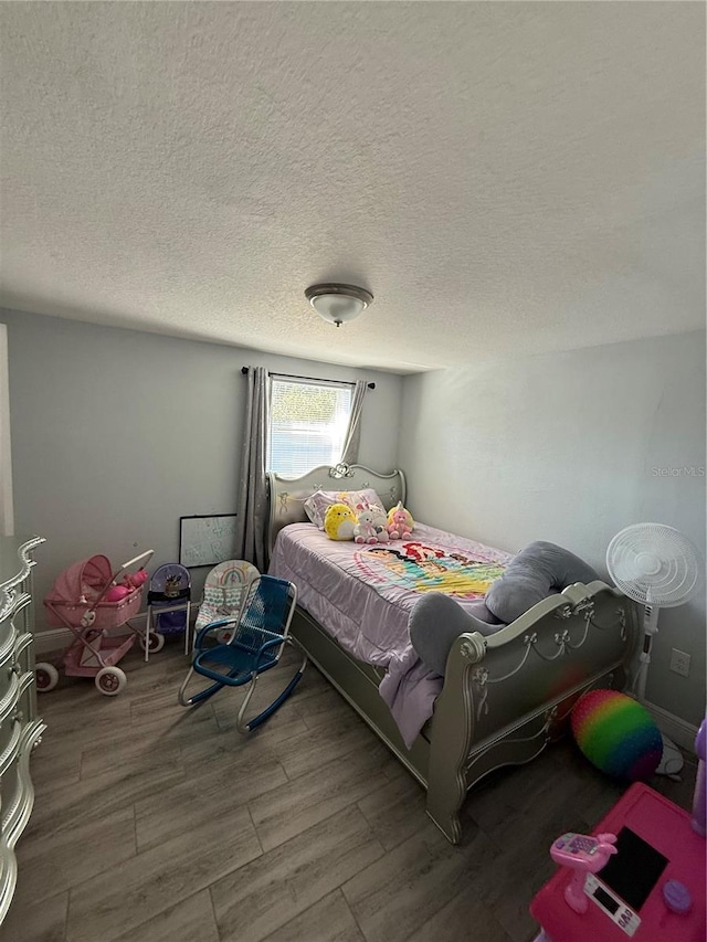 bedroom featuring hardwood / wood-style flooring and a textured ceiling