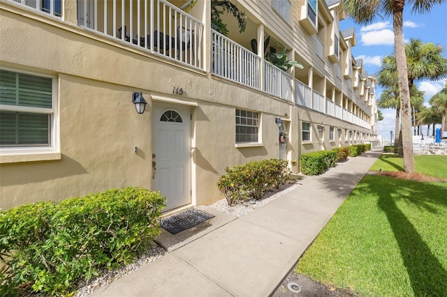 exterior space featuring a balcony and a yard