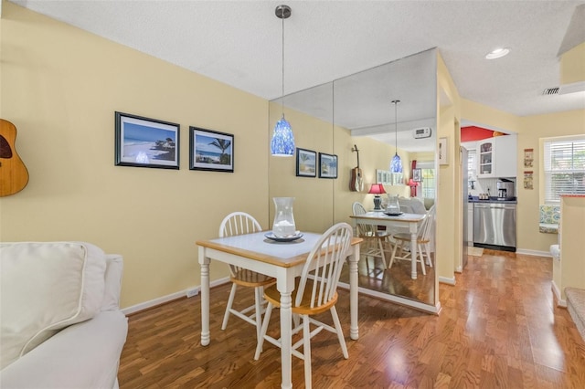 dining area featuring hardwood / wood-style flooring and a textured ceiling