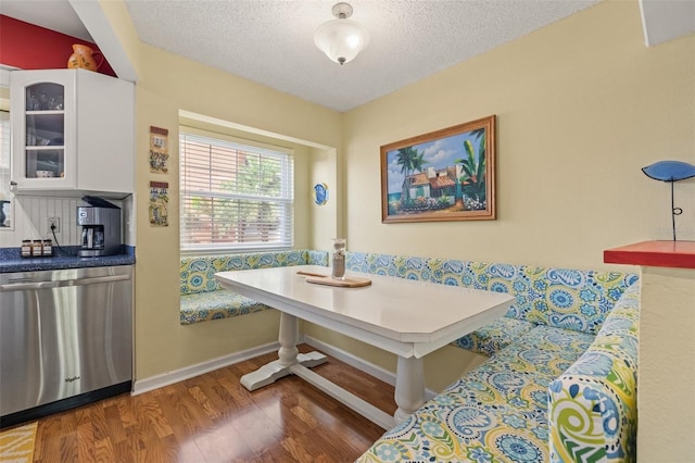 dining room with a textured ceiling, breakfast area, and dark wood-type flooring