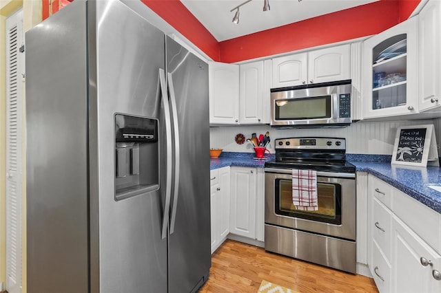 kitchen with light hardwood / wood-style floors, white cabinetry, and stainless steel appliances