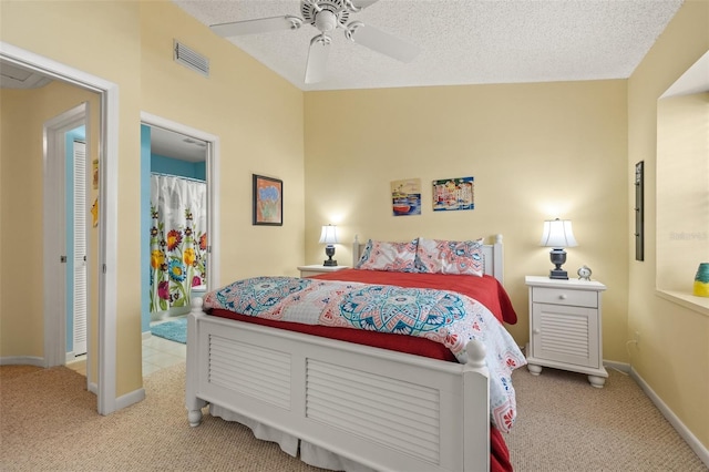 carpeted bedroom with ceiling fan and a textured ceiling