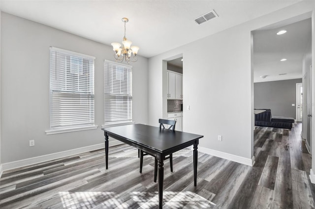 office space featuring dark wood-type flooring and an inviting chandelier