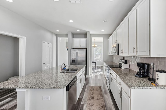 kitchen with white cabinets, an island with sink, and stainless steel appliances