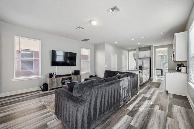 living room with a chandelier and light wood-type flooring