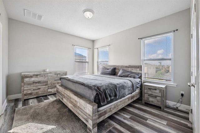 bedroom with dark hardwood / wood-style flooring