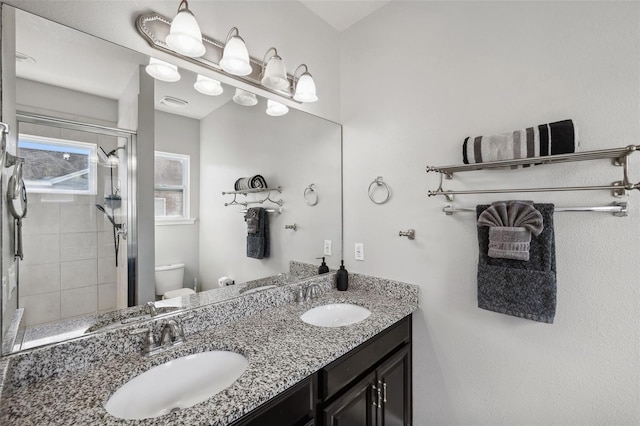 bathroom featuring an enclosed shower, vanity, and toilet