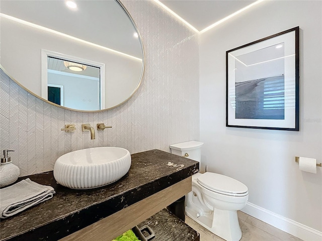 bathroom featuring toilet, tile patterned flooring, and sink