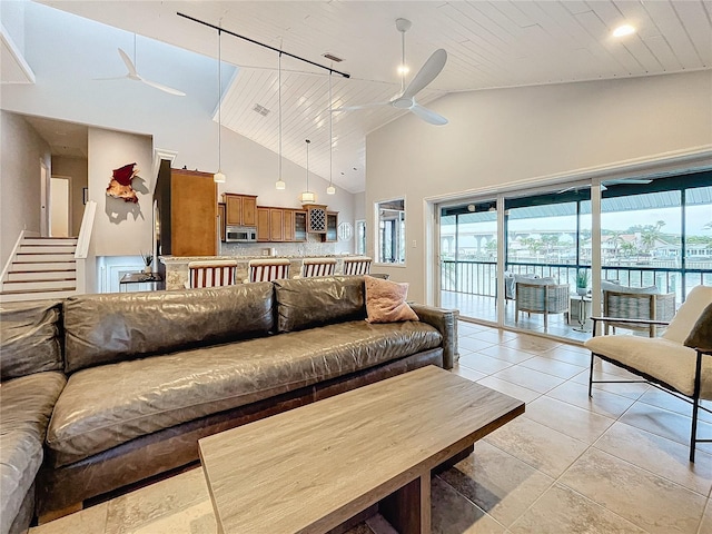 tiled living room with a towering ceiling, ceiling fan, and wood ceiling