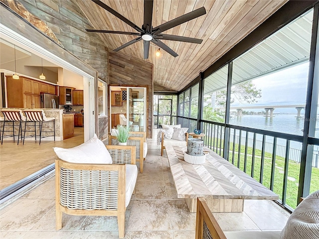 sunroom featuring ceiling fan, vaulted ceiling, wood ceiling, and a water view