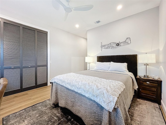 bedroom with hardwood / wood-style floors, a closet, and ceiling fan