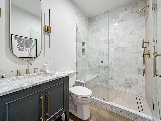 bathroom featuring toilet, an enclosed shower, wood-type flooring, and vanity