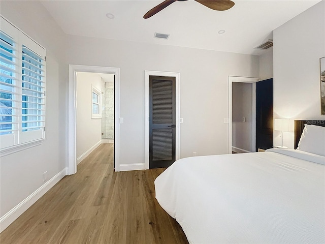 bedroom with wood-type flooring, ensuite bath, and ceiling fan