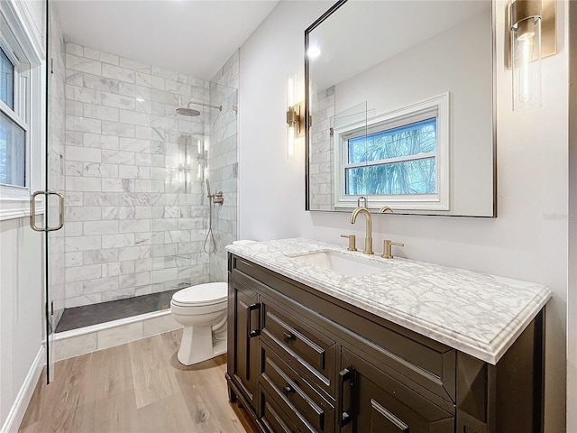 bathroom with a shower with door, toilet, vanity, and hardwood / wood-style flooring