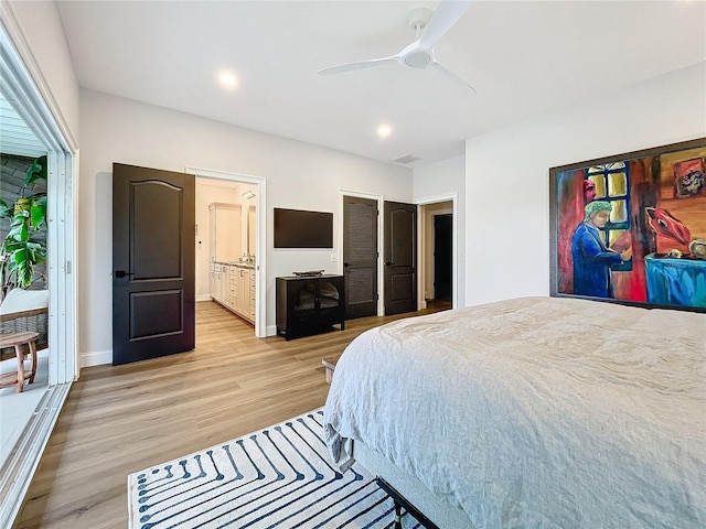 bedroom featuring ceiling fan, light hardwood / wood-style flooring, and ensuite bath