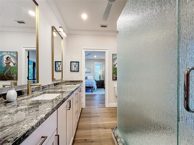 bathroom featuring ceiling fan, a shower with shower door, ornamental molding, hardwood / wood-style flooring, and vanity