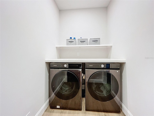 laundry area with light hardwood / wood-style flooring and washing machine and dryer