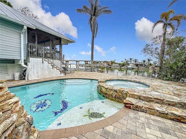 view of pool with a patio, a sunroom, an in ground hot tub, and a water view