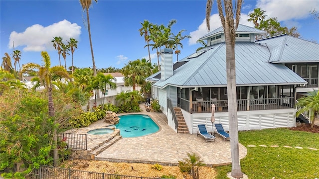 view of pool with a lawn, an in ground hot tub, a sunroom, and a patio area