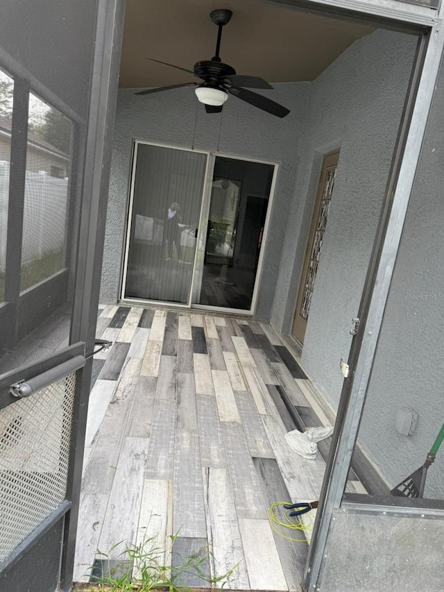 unfurnished sunroom featuring ceiling fan