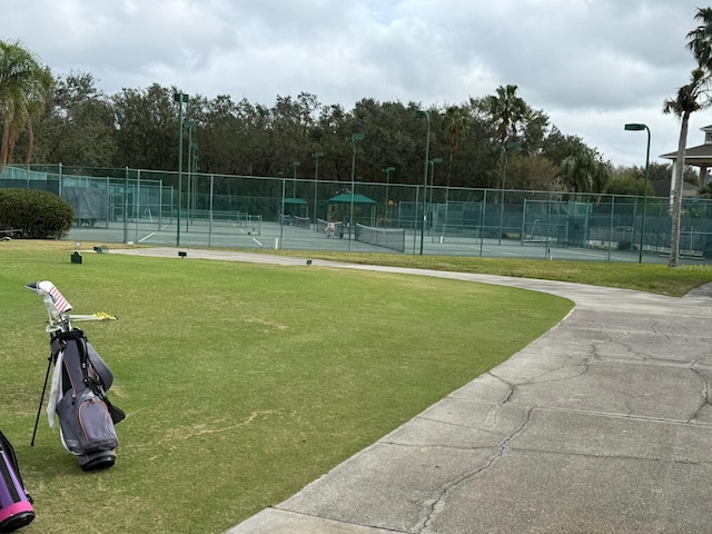 view of tennis court with a yard