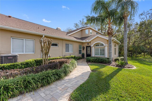 view of front of property featuring central AC unit and a front lawn