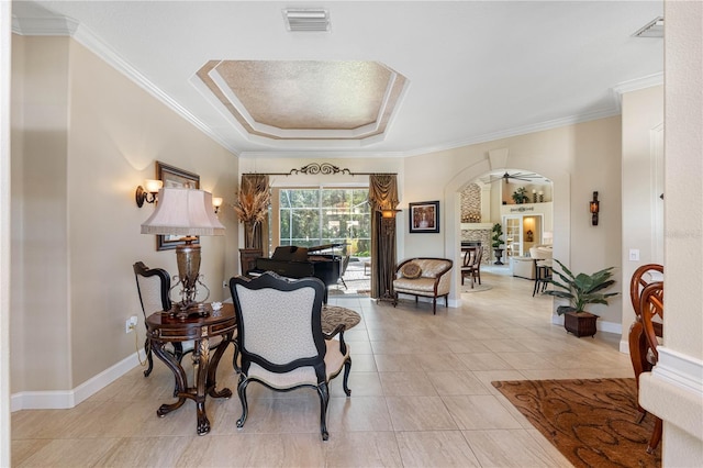 sitting room featuring ornamental molding, light tile patterned floors, and a tray ceiling