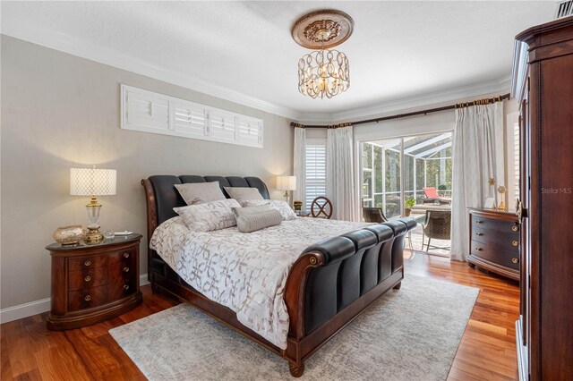 bedroom featuring ornamental molding, access to exterior, a chandelier, and light hardwood / wood-style flooring