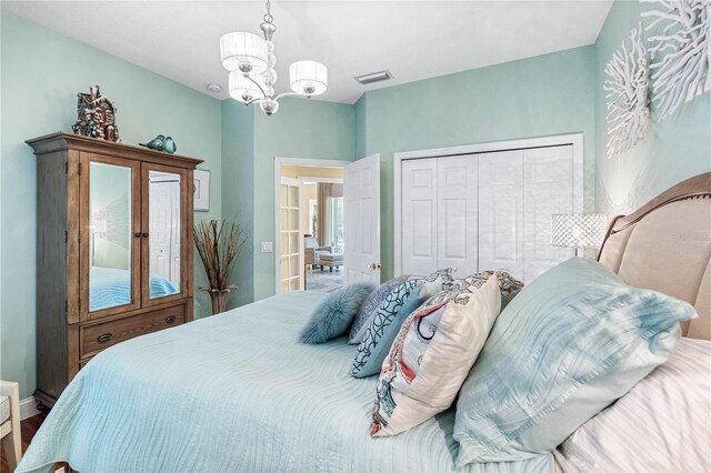 bedroom featuring an inviting chandelier and a closet