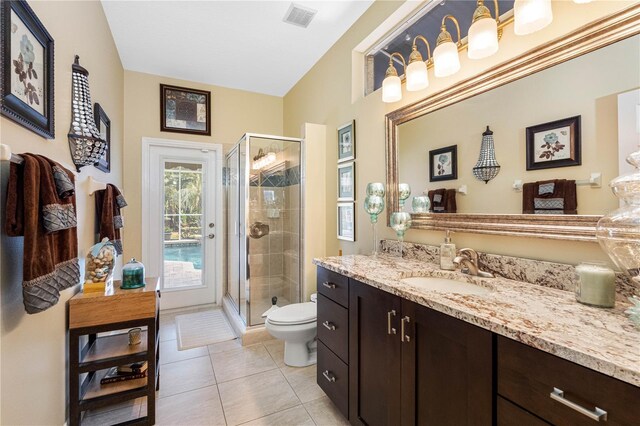 bathroom featuring vanity, tile patterned flooring, toilet, and walk in shower