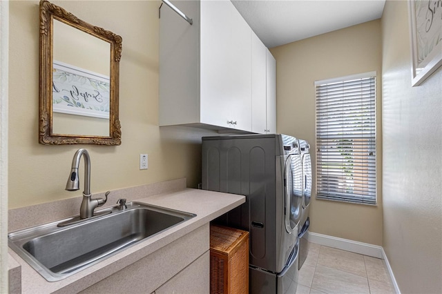 clothes washing area with cabinets, washing machine and dryer, sink, and light tile patterned flooring