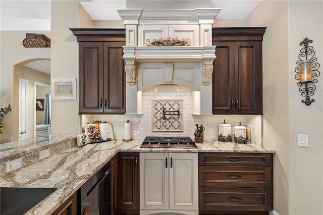 kitchen featuring wine cooler, light stone countertops, stainless steel gas cooktop, and dark brown cabinets