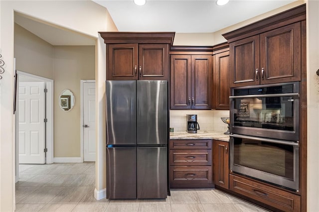 kitchen with tasteful backsplash, light stone countertops, dark brown cabinets, and stainless steel appliances