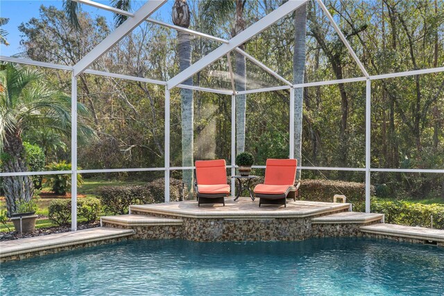 view of swimming pool featuring a patio and a lanai