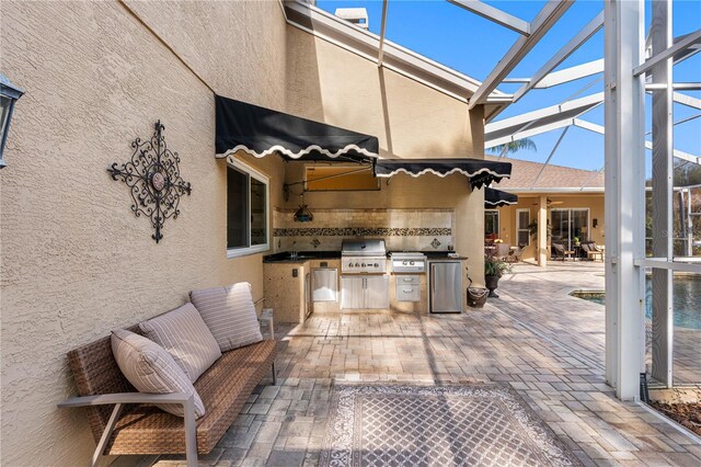 view of patio / terrace featuring exterior kitchen, a lanai, and area for grilling