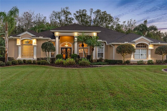 view of front facade with a lawn and french doors