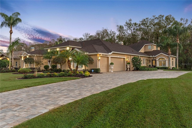 view of front of house featuring a garage and a yard