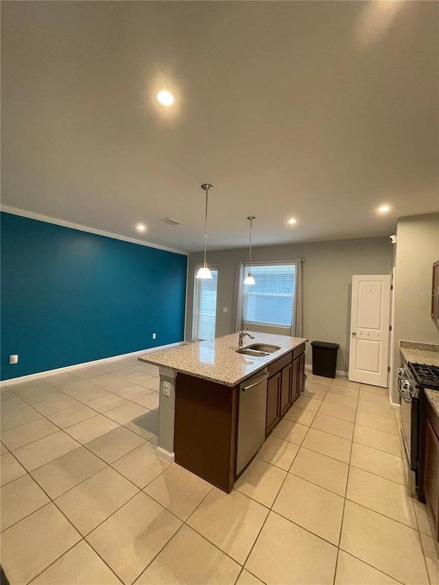 kitchen featuring appliances with stainless steel finishes, dark brown cabinets, a kitchen island with sink, sink, and pendant lighting