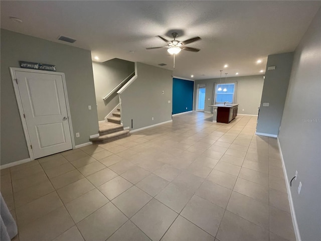 unfurnished living room with ceiling fan and light tile patterned floors